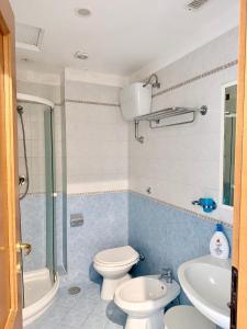 a bathroom with a toilet and a sink and a shower at Hotel Dania in Sorrento