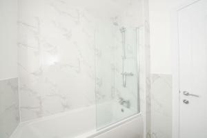 a white bathroom with a shower and a tub at Stylish 3-Bed Home-Liverpool in Liverpool +20 photos