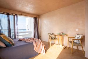 a bedroom with a bed and a table and a window at Formentera Especial in La Savina