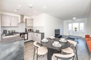 a kitchen and living room with a table and chairs at Stylish 3-Bed Home-Liverpool in Liverpool