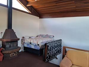 a bedroom with a bed and a wood stove at Cantinho da Serra in Santo Antônio do Pinhal