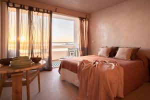 a bedroom with a bed and a table with a window at Formentera Especial in La Savina
