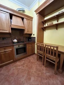 a kitchen with wooden cabinets and a table and chairs at Royal in Kraków