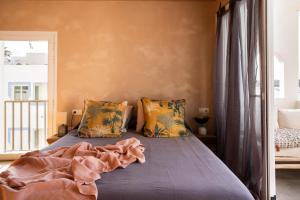 a bedroom with a bed with blue sheets and a window at Formentera Especial in La Savina