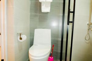 a bathroom with a white toilet and a shower at Laurell Hill Suites, Upper Hill in Nairobi