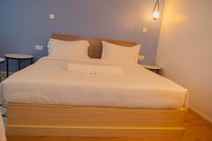 a bedroom with a large bed with white sheets and pillows at Laurell Hill Suites, Upper Hill in Nairobi