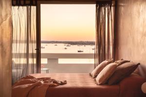 a bedroom with a bed with a large window at Formentera Especial in La Savina