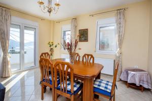 a dining room with a wooden table and chairs at Villa Rafailia in Skala Marion