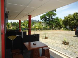 a table and chairs on a patio with a yard at Kirana Guestroom in Kuala Tahan