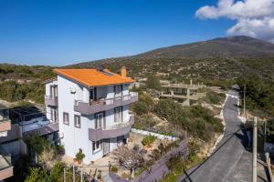 a white house with an orange roof and a road at Villa Rafailia in Skala Marion