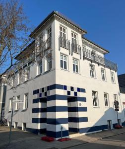 a large white building with a black and white stripes at Apartments in Warnemuende in Warnemünde