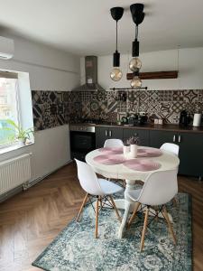 a kitchen with a table and chairs in a room at Ca acasă Corbu in Corbu