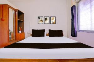 ナーシクにあるHotel O Paradiseの大きな白いベッドと窓のある寝室