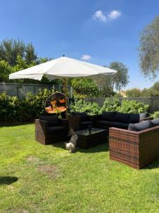 a patio with a couch and an umbrella at Unique villa in madinaty in Madinaty