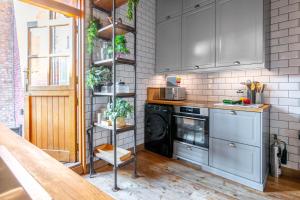 a kitchen with gray cabinets and a black dishwasher at Swift Host - 2 Bedrooms - Norwich Lanes Duplex - Central - Great Location - Parking in Norwich
