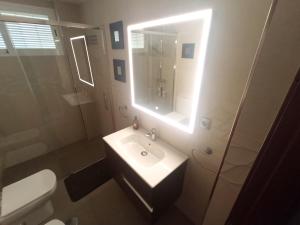 Un baño con lavabo, inodoro y espejo. en Casa de Nina, en Córdoba