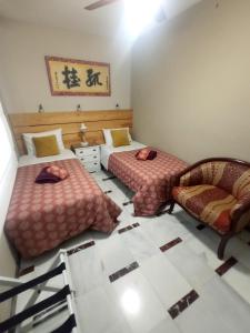 Una habitación con dos camas y una silla dentro. en Casa de Nina, en Córdoba 42 fotos más