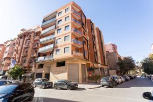 a tall building on a city street with parked cars at Migdal Calavon in Marrakech