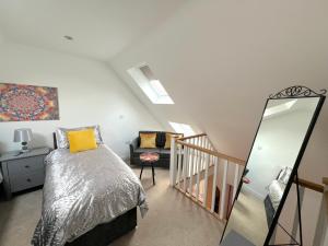 a bedroom with a bed and a mirror at Glastonbury Hidden Passage, Split Level 1 Bedroom Apt in Glastonbury