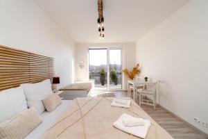 a white bedroom with a large bed and a desk at New BNB Apartment In the Ostrava with parking option in Slezská Ostrava