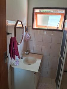 a bathroom with a sink and a mirror and a window at Cantinho da Serra in Santo Antônio do Pinhal