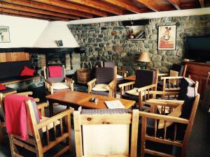 a dining room with tables and chairs and a stone wall at Hôtel Le Monte Pente in Vars