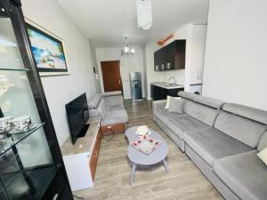 a living room with a couch and a table at Keivin Apartment 3 in Vlorë +2 photos