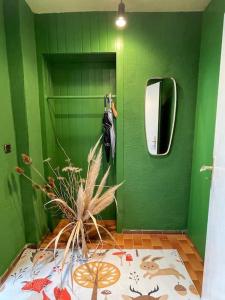 a green bathroom with a mirror and a green wall at Hübsche Wohnung mit Gartennutzung in Grevenbroich