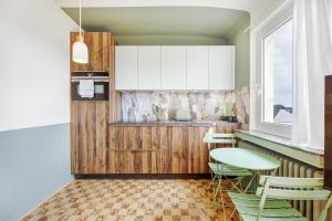 a kitchen with wooden cabinets and a table and chairs at Stylish & Modern City Escape In Bonnevoie in Luxembourg