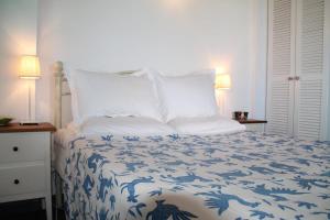 a bedroom with a bed with a blue and white comforter at The Iconpainter Marathi Villa in Kómboi