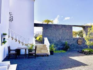 a patio with a table and chairs and stairs at Serenity House in Tinajo +3 photos