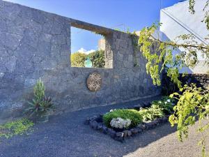 a garden with a stone wall and some plants at Serenity House in Tinajo