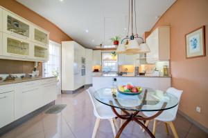 a kitchen with a glass table and white cabinets at Binife - Villa exclusiva con piscina climatizada in Alaior