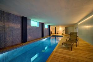 a swimming pool with a chair in a house at Binife - Villa exclusiva con piscina climatizada in Alaior +29 photos