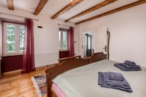 a bedroom with a bed and two windows at Apartment in GREEN with private SAUNA and WHIRLPOOL Bathtube in Matulji