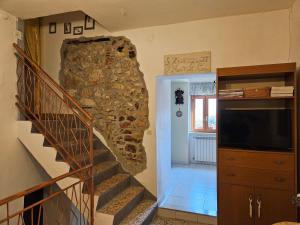 a living room with a staircase and a stone wall at Casa di Mamma Rosa in Castelnuovo Parano