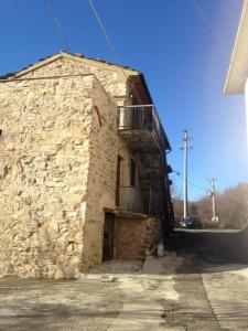 a stone building with a balcony on the side of it at La casa del bosco in Bagnone +18 photos