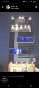 AgarPremshree Hotel的一张建筑的图片,上面有蓝色的灯光