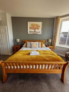 a bedroom with a large bed with a yellow bedspread at The Corbet Arms in Shrewsbury