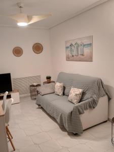 Un dormitorio con una cama y un televisor de pantalla plana. en Apartamento en la playa de Cala Capitán -Cabo Roig- Orihuela Costa, en Orihuela