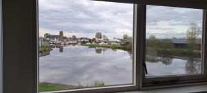 a window with a view of a body of water at Wetterkantwoning in Grou