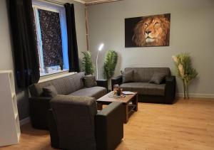 een woonkamer met 2 banken en een tijgerschilderij bij Flensburg Süd in Flensburg