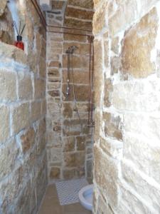 ein Steinbadezimmer mit einer Dusche in einer Ziegelwand in der Unterkunft alaséu in Bitonto