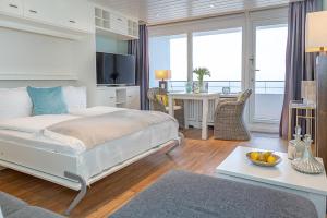 a bedroom with a bed and a living room with a table at Metropol Oceanlounge 309A in Westerland (Sylt)