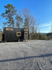 a black shipping container sitting on the side of a road at Mountain Top Tiny House by Beyond Expectations in Waldens Creek