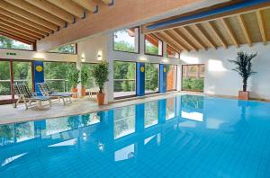 a swimming pool in a house with blue water at Hotel Sonne Baiersbronn in Baiersbronn
