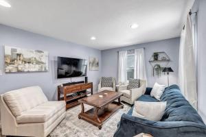 a living room with a couch and chairs and a tv at The Green Bay House of Blues in Green Bay