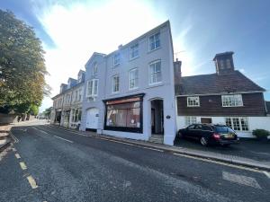 un coche aparcado delante de un edificio blanco en Hurstpier Spacious 2 Bed Apartment - by MCF, en Hurstpierpoint