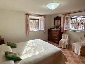 a bedroom with two beds and a dresser and two windows at Casa Mary in Lucca