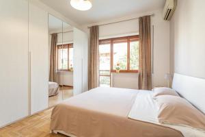Una cama grande en una habitación con una ventana grande. en St Peter apartment with Garage, en Roma